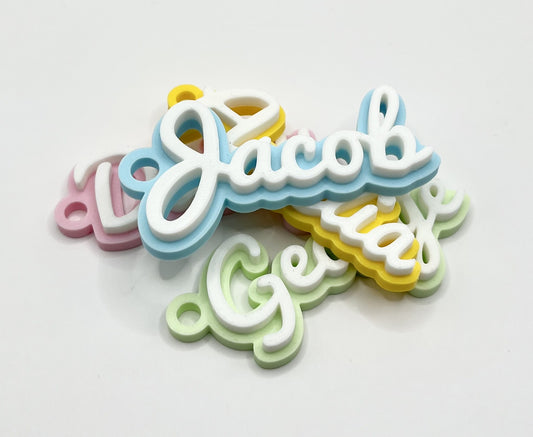 Personalised kids name bag tag keychain charm, for childrens school / pre school identification for early years bags, stunning contrast of their name in a cute script font on a sturdy, thick plastic name tag in white on top of a pastel/bold colour of your choosing for the base. Comes with a quality flat split ring in stainless steel and strong small plastic clip. Attatch to kids adventure day bags or school bags for a nice touch
