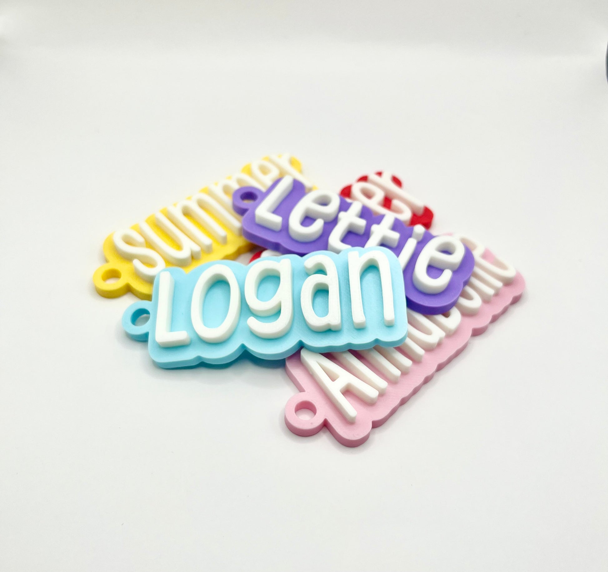 Personalised kids name bag tag keychain charm, for childrens school / pre school identification for early years bags, stunning contrast of their name in a cute tall, thin font on a sturdy, thick plastic name tag in white on top of a pastel/bold colour of your choosing for the base. Comes with a quality flat split ring in stainless steel and strong small plastic clip. Attatch to kids adventure day bags or school bags for a nice touch